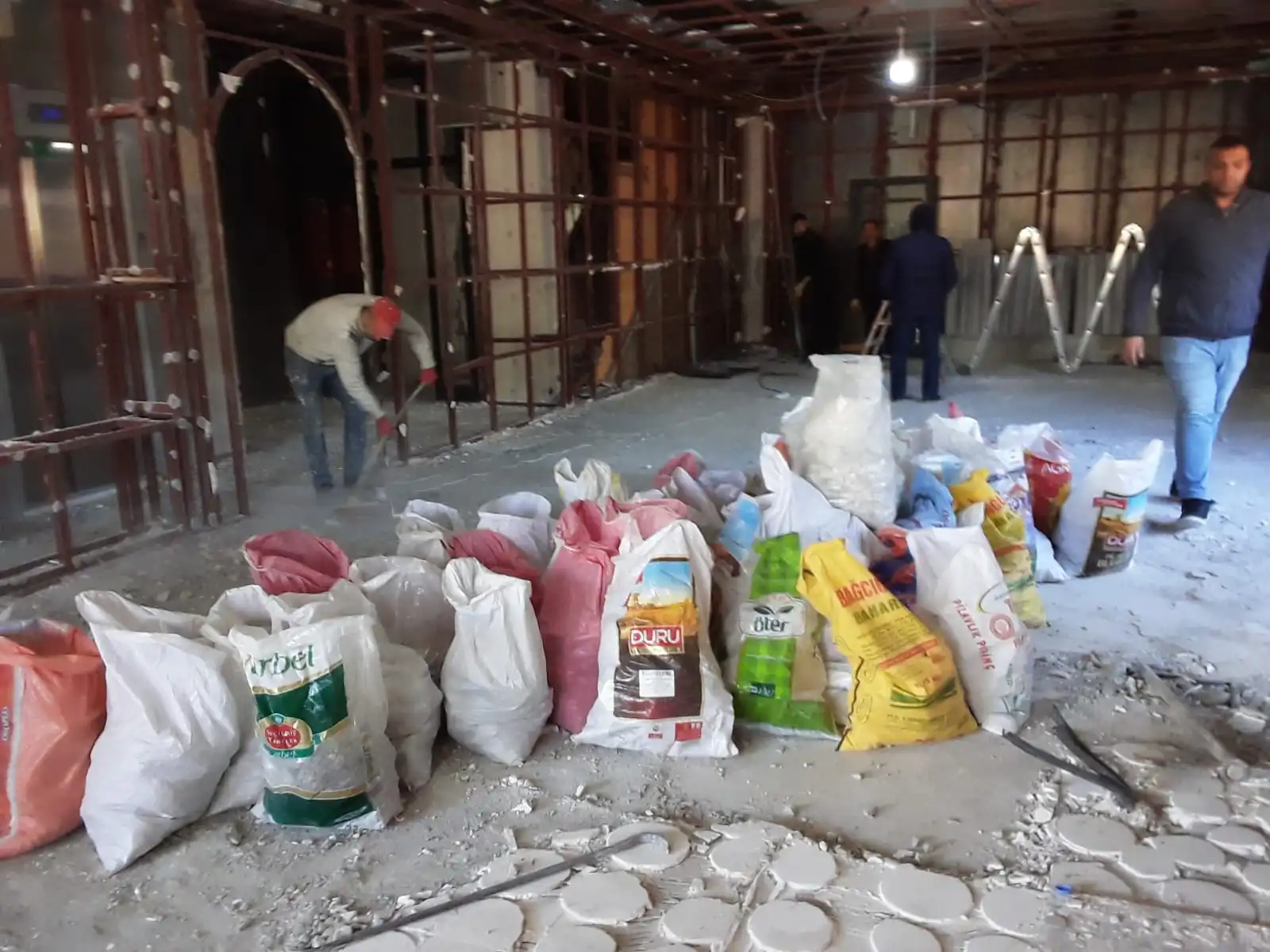 Çuvallara doldurulmuş inşaat molozları ve çalışan işçiler